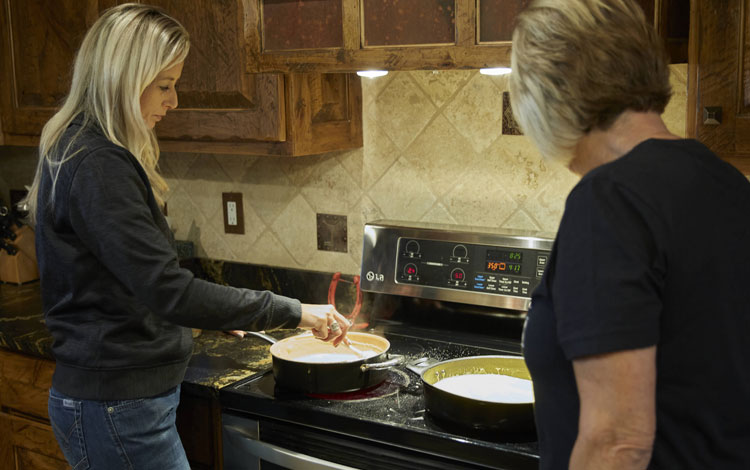 Shali standing in the kitchen cooking dinner with her mom.
